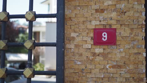 casa número 9 con puerta de metal y pared de piedra