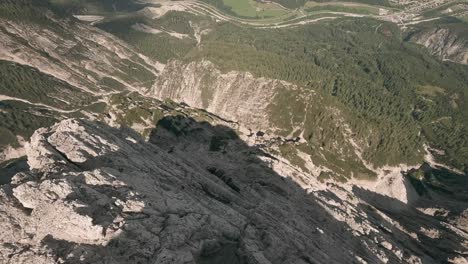 action camera footage from fpv racing drone flying fast and very close down a mountain canyon in austria in summer