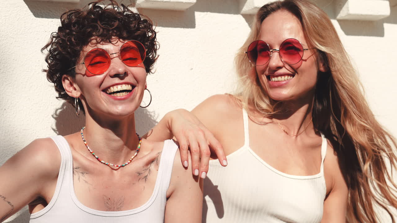 две женщины смеются на открытом воздухе.