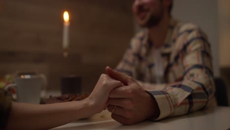 couple holding hands during dinner