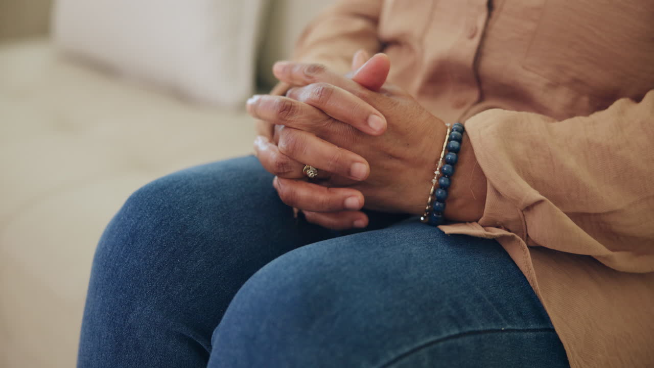 Close Up of Person's Clasped Hands Resting on Lap