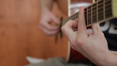 close-up of a man playing acoustic guitar