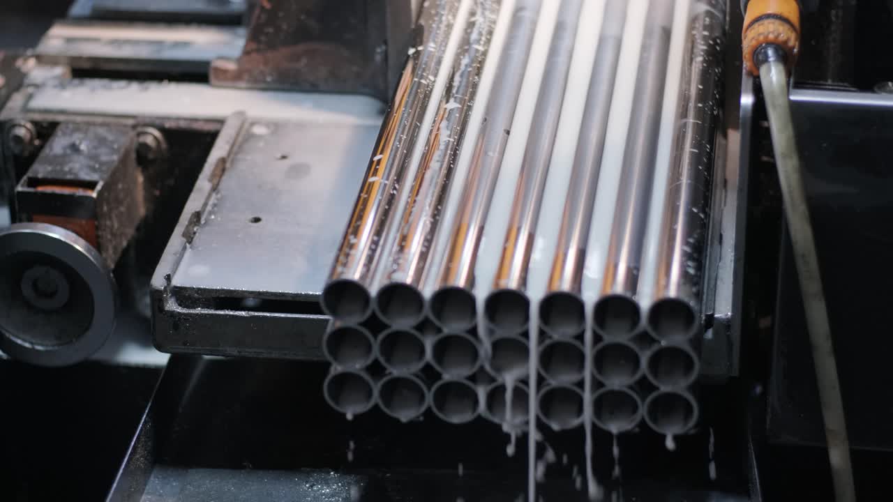 Cutting stainless steel pipes, the band saw for industrial cutting the metal stainless pipe and using the coolant heating. The industrial tool.