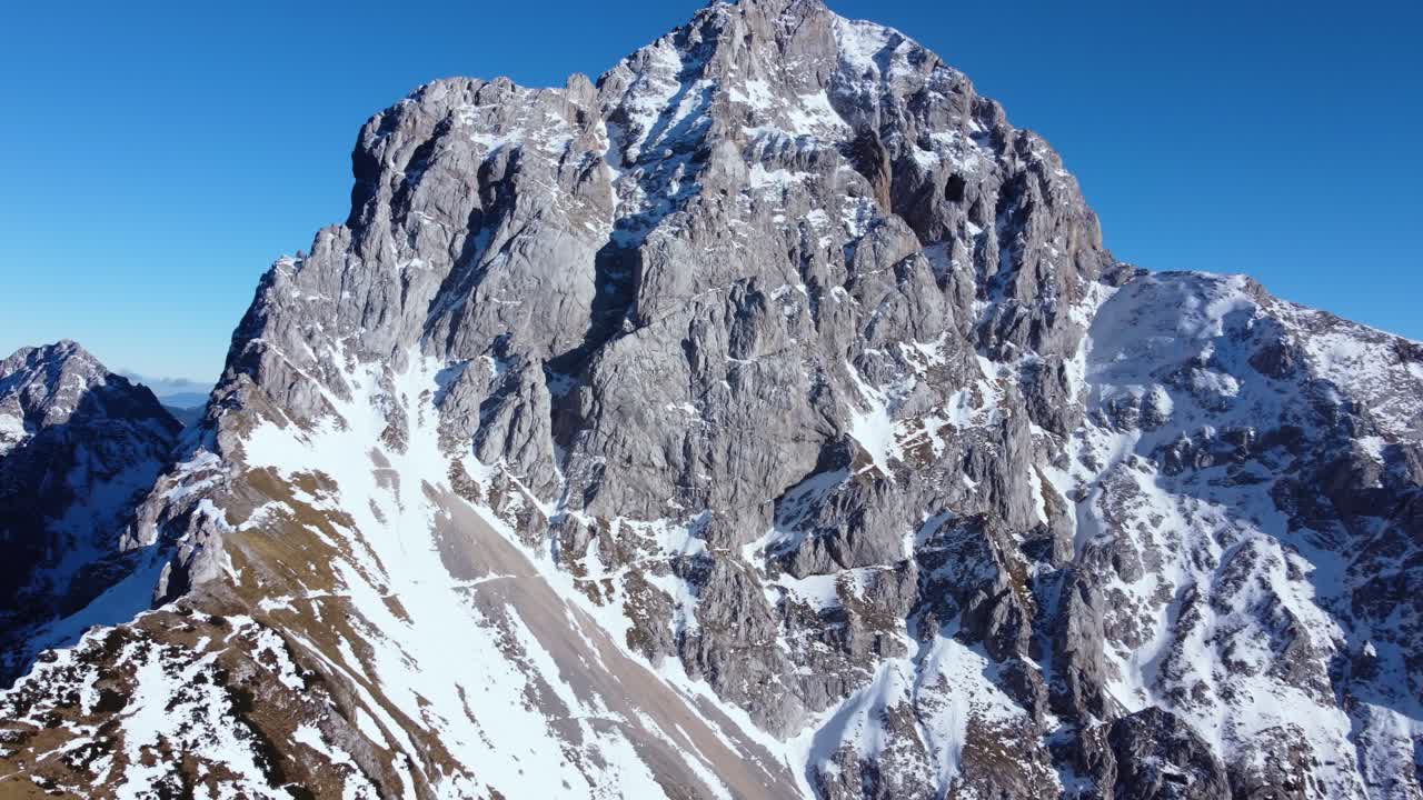 Ripresa aerea laterale con panoramica della vetta innevata di una montagna mozzafiato sulle Alpi slovene