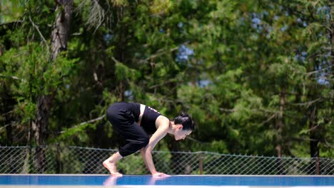 Frau-Macht-Yoga-Am-Pool