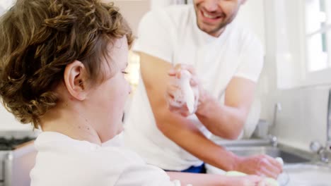 Son-helping-father-in-washing-utensils