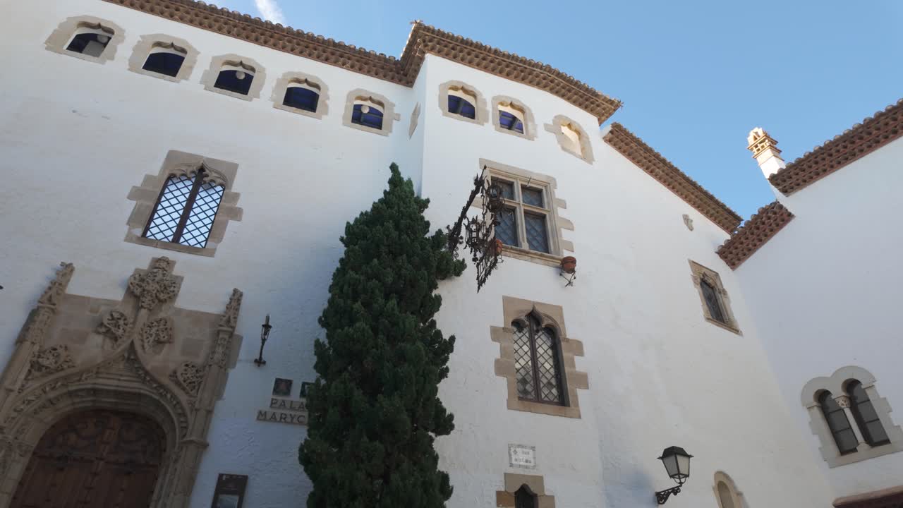 White historic facade with ornate windows at Palau de Maricel in Sitges Spain