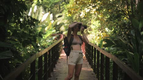 female traveler photographer taking photo's of beautiful cahuita natural rainforest on boardwalk