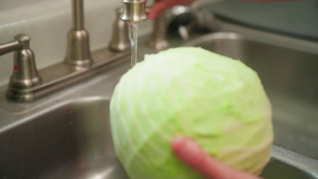 Washing cabbage in the sink by hand