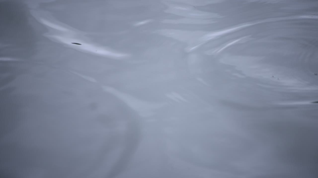 雨のゆっくりとした動き池の水中を落とす雨の日のクローズアップ