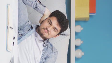 Vertical-video-of-Man-lying-on-the-sofa-is-resting.