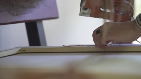 Close-up-shot-of-woman-using-stapler-in-factory,-production-of-art-wall-picture