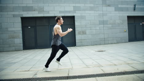 Fitness-man-running-on-urban-street-in-slow-motion.-Male-runner-jogging-outdoor.