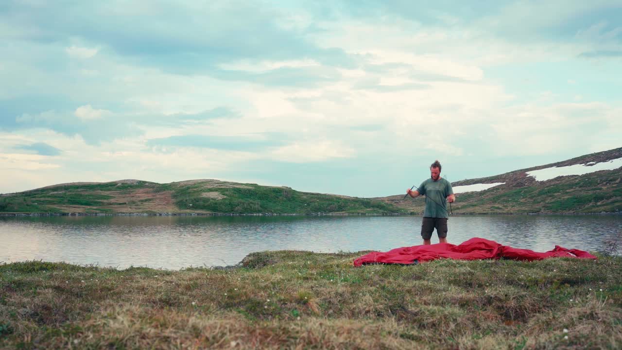 человек, устанавливающий палатку возле озера имфельсватнет, индере фосен, норвегия