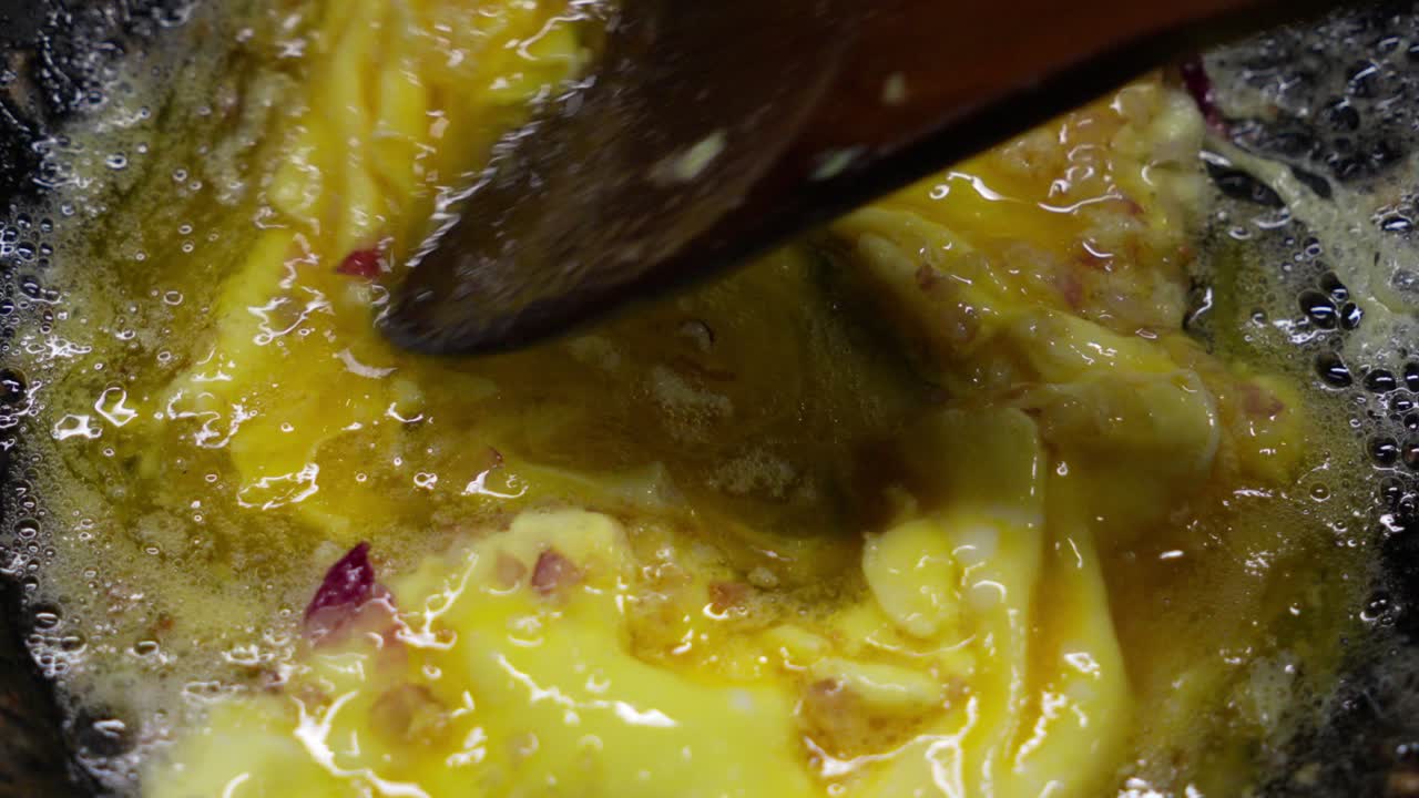 Scrambled eggs cooking with onions in a pan, vibrant and appetizing