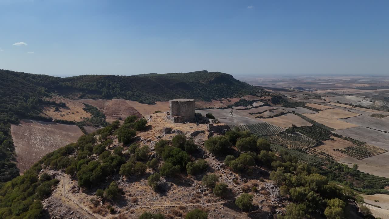 Aerial view of Castillo de Cote, a medieval hilltop fortress in Montellano, Seville, Spain, showcasing its ancient stone walls and vast Andalusian landscape on a bright, clear day