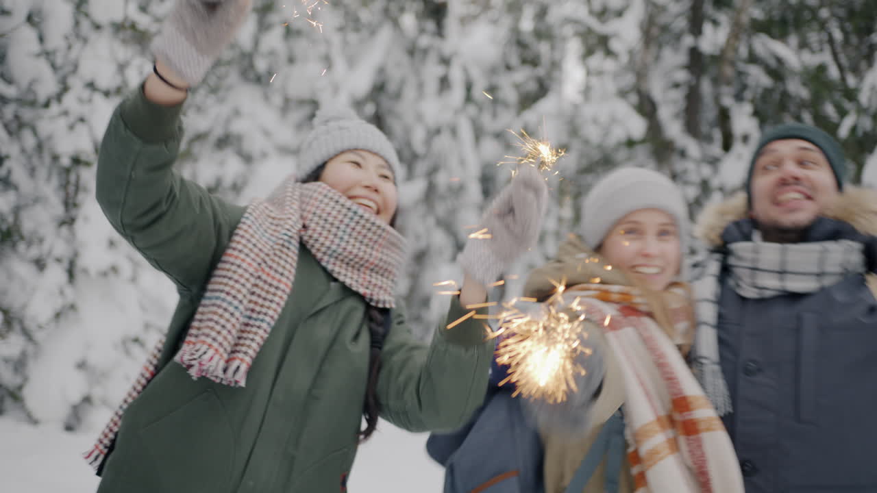 Friends having fun with sparklers in the snow