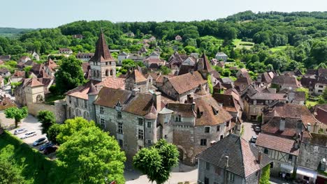 Small,-medieval-village-situated-next-to-a-river,-flowing-through-a-rich-forest-in-the-heart-of-France