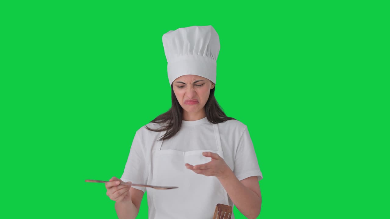 Chef professionista indiana che assaggia cibo cattivo su schermo verde