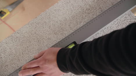top shot of handyman marking a acoustic panel using a pencil and a folding ruler close up 4k