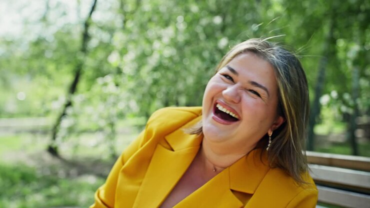 Donna curvy che ride in un parco