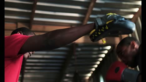 boxeador afroamericano practicando boxeo con el entrenador en el gimnasio 4k