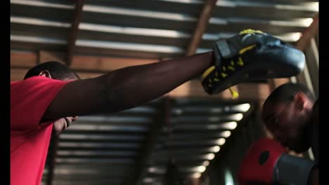 african american male boxer practicing boxing with trainer in gym 4k