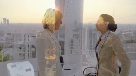 Animation-of-businesswomen-handshake-over-cityscape