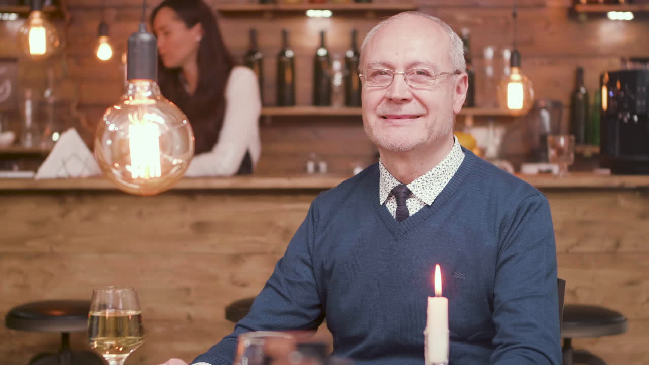 Man sitting at a restaurant table with a candle