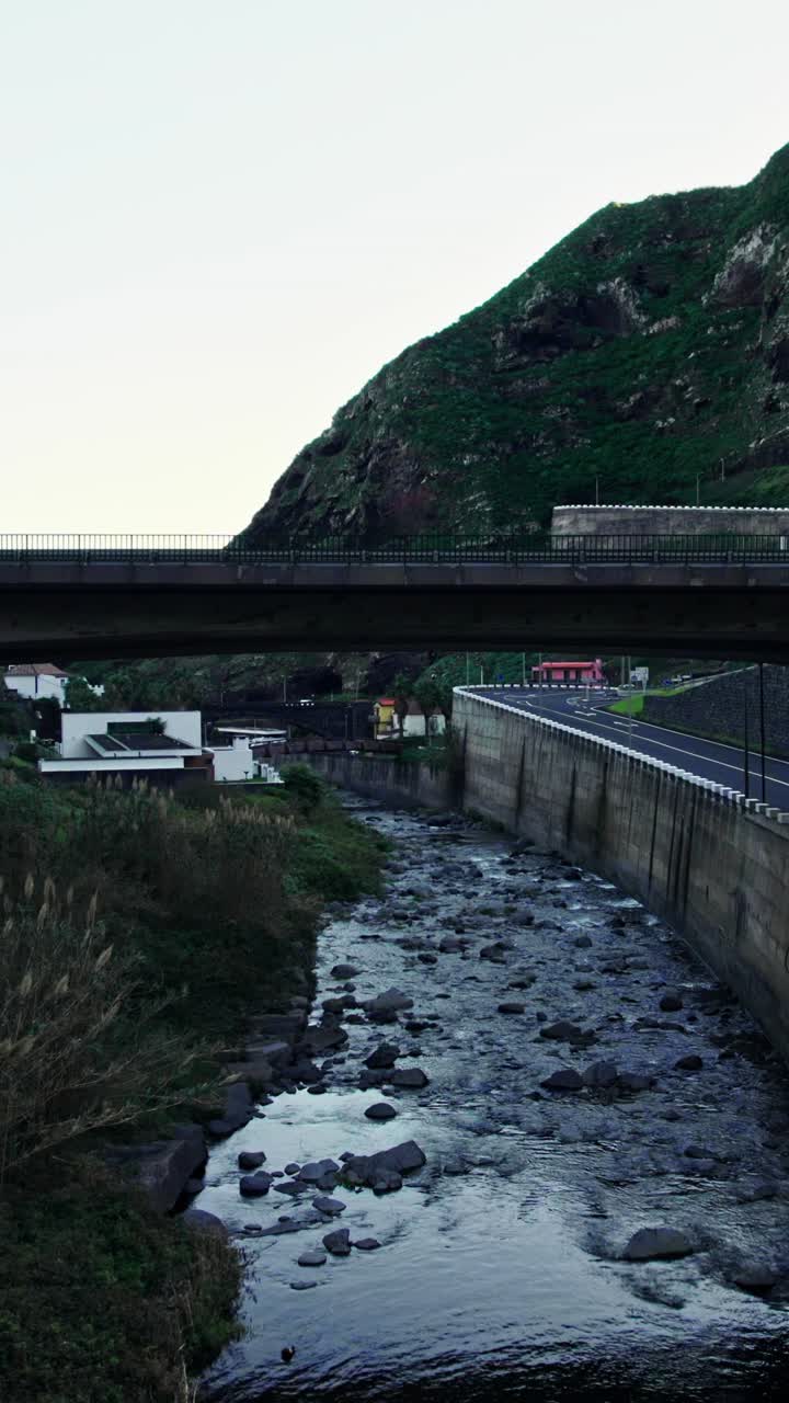 River Under a Bridge in a Mountainous Town