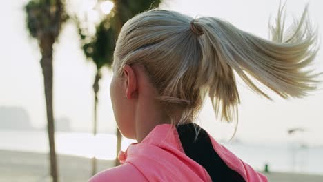 handheld video shows of female runner on the beach