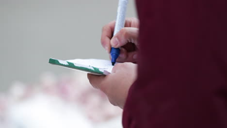 Image-Of-A-Hand-Holding-Pentel-Pen-Marker-Writing-Use-For-Labeling-His-Merchandise-At-Market-In-Leiria,-Portugal