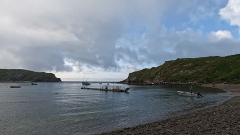 Un-Hombre-Tiende-A-Su-Bote-En-Lulworth-Cove,-Dorset,-Inglaterra