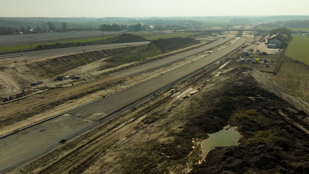 vista aérea expansiva de una carretera en construcción, que muestra maquinaria y carreteras parcialmente terminadas