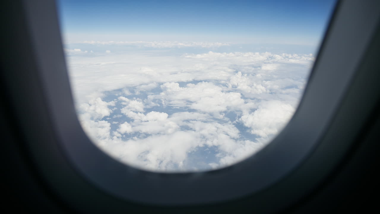 Aerial view of white, fluffy clouds from an airplane window