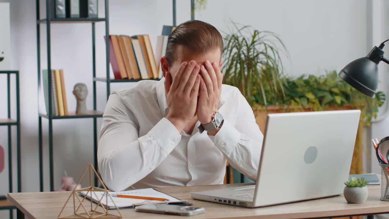 Irritated tired businessman working on laptop website problem computer virus data loss by hacking