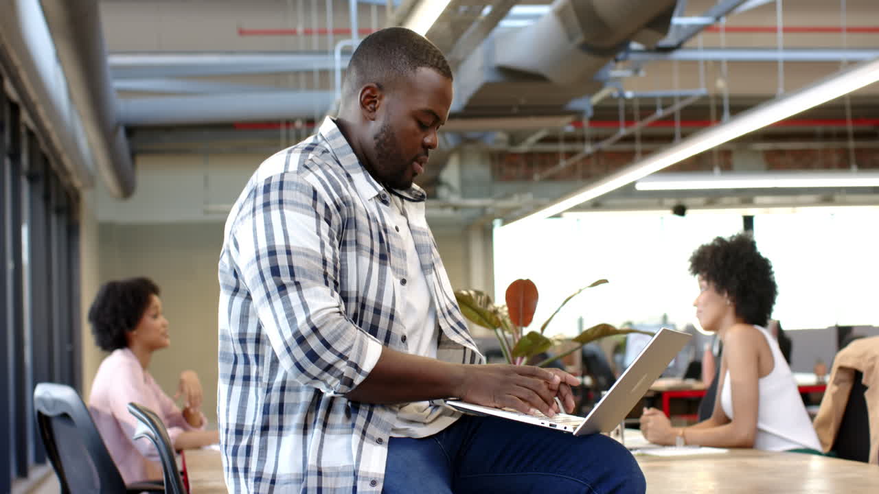 African American man using laptop in modern office