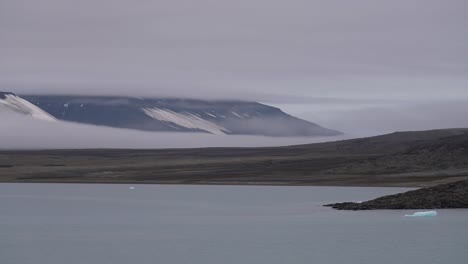 niebla y niebla sobre la isla bajo colinas y glaciares en el círculo ártico 60 fps