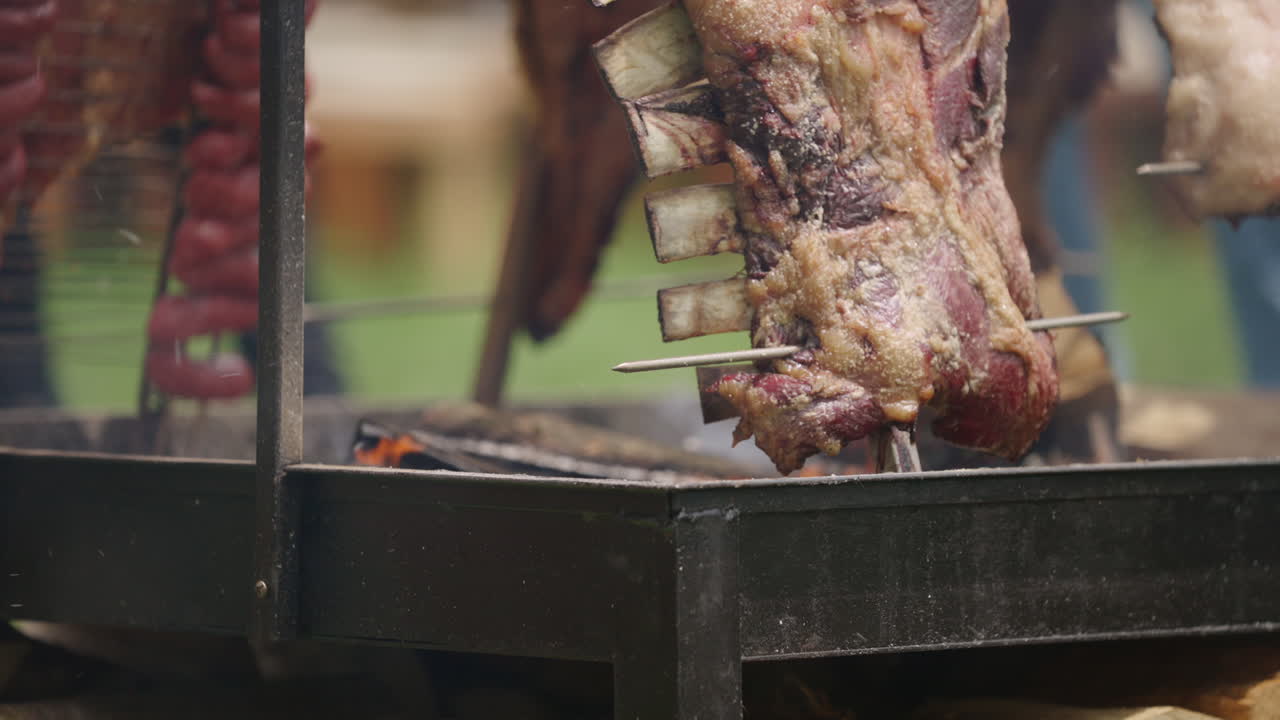 Close-up of traditional Argentinian asado ribs roasting over open fire on outdoor grill