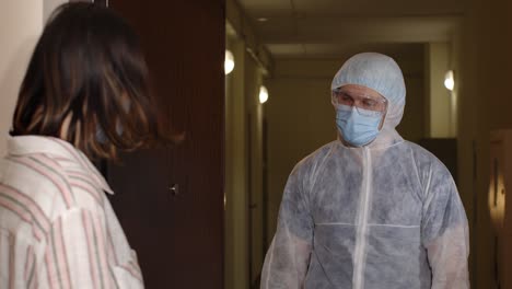 medical worker with text on paper visiting woman at home offering vaccination against coronavirus