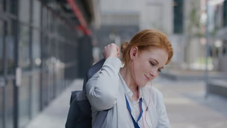 Retrato-Feliz-Joven-Pelirroja-Mujer-De-Negocios-Pasante-Sonriendo-Disfrutando-De-Un-Estilo-De-Vida-Urbano-Profesional-Usando-Auriculares-En-Cámara-Lenta-De-La-Ciudad