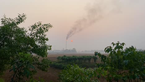 establisher static shot of gas burning tower plant polluting rural countryside