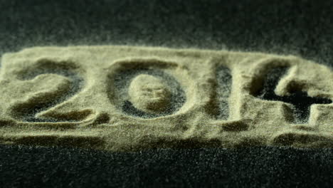 2014 spelled out in sand blowing away