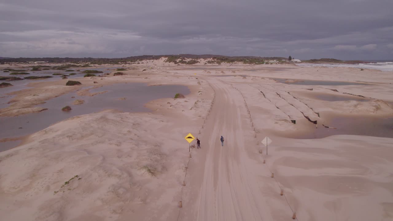 gente caminando por un sendero arenoso cerca de la playa de stockton en la región de cazadores de nueva gales del sur, australia