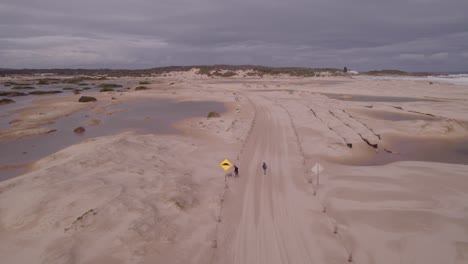 people walking on sandy trail near stockton beach in the hunter region of new south wales, australia