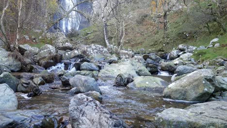 fresh idyllic autumn mountain forest waterfall flowing and splashing over river boulders left dolly