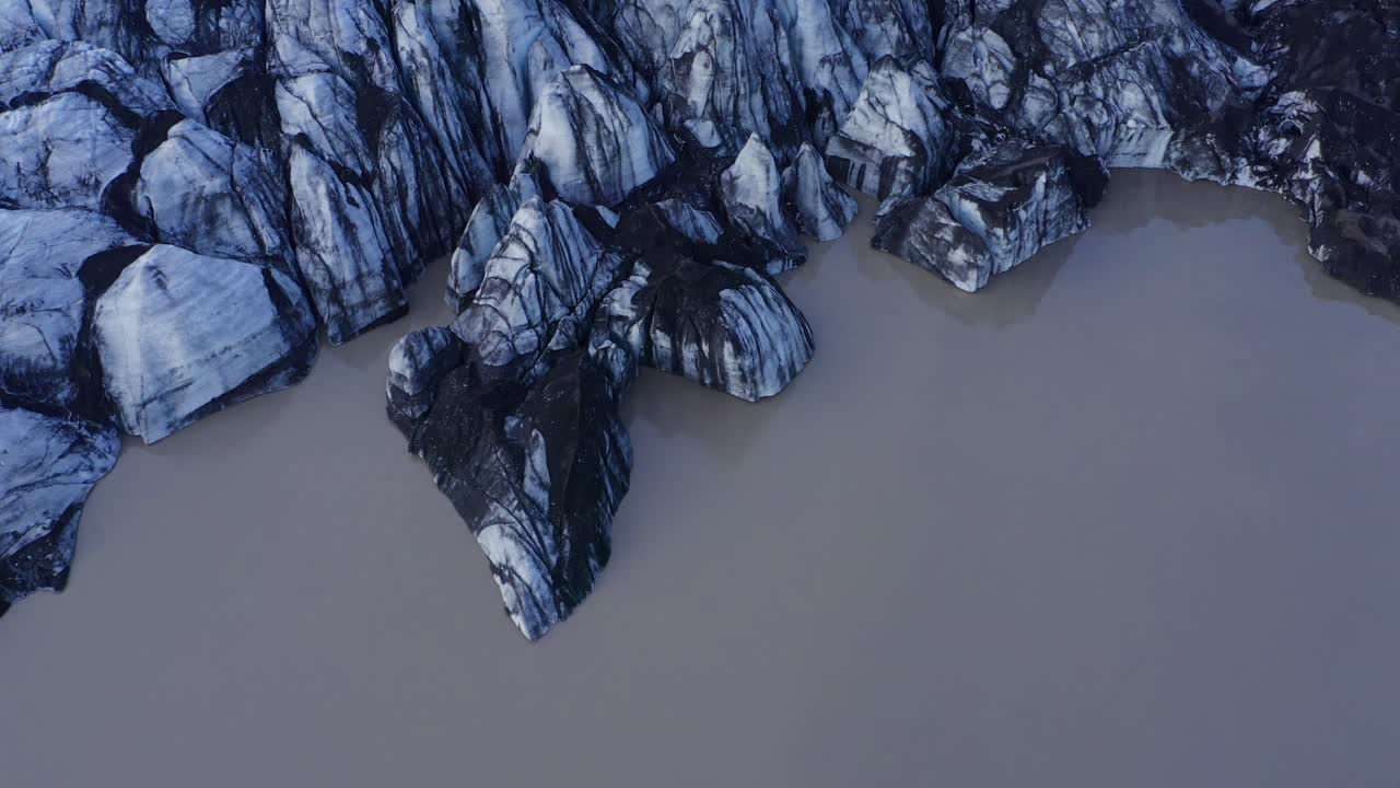 sobrevolando las hermosas carvasses de icebergs en la salida del glaciar solheimajokull con montañas islandesas detrás en el sur de islandia