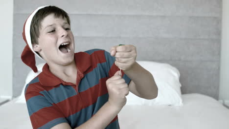 Happy-boy-using-party-popper-in-the-bedroom-in-black-and-white