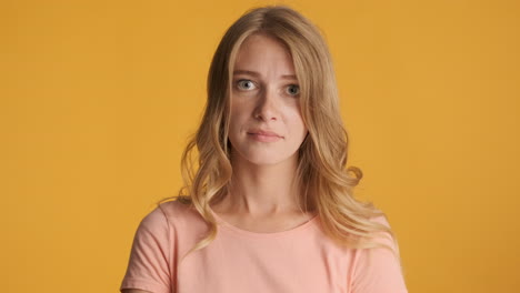 Upset Caucasian woman waving hand on camera.
