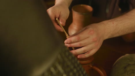 servant decorates knight drink with straw in tavern. scared innkeeper smiles to noble lord tasting beverage at counter closeup. medieval roadside pub